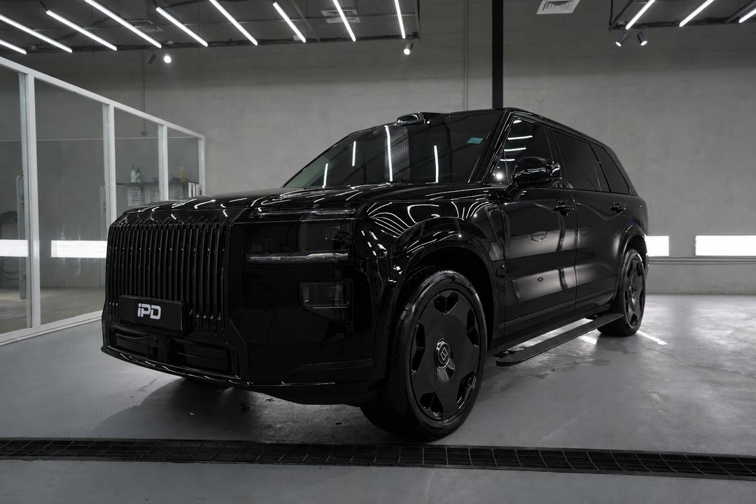 AI visualisation of the same front view with the grille, trim and wheels in gloss black and the wheel centre logos in their original colour.