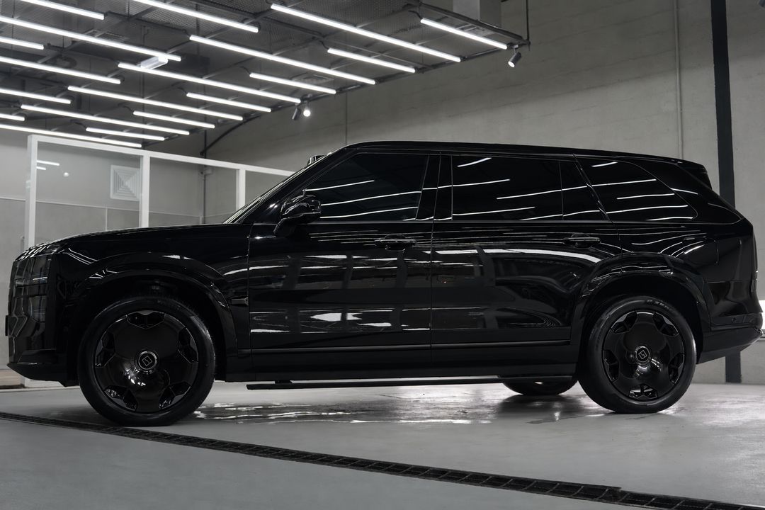AI visualisation of the same side view with the trim and wheels in gloss black and the wheel centre logos in their original colour.