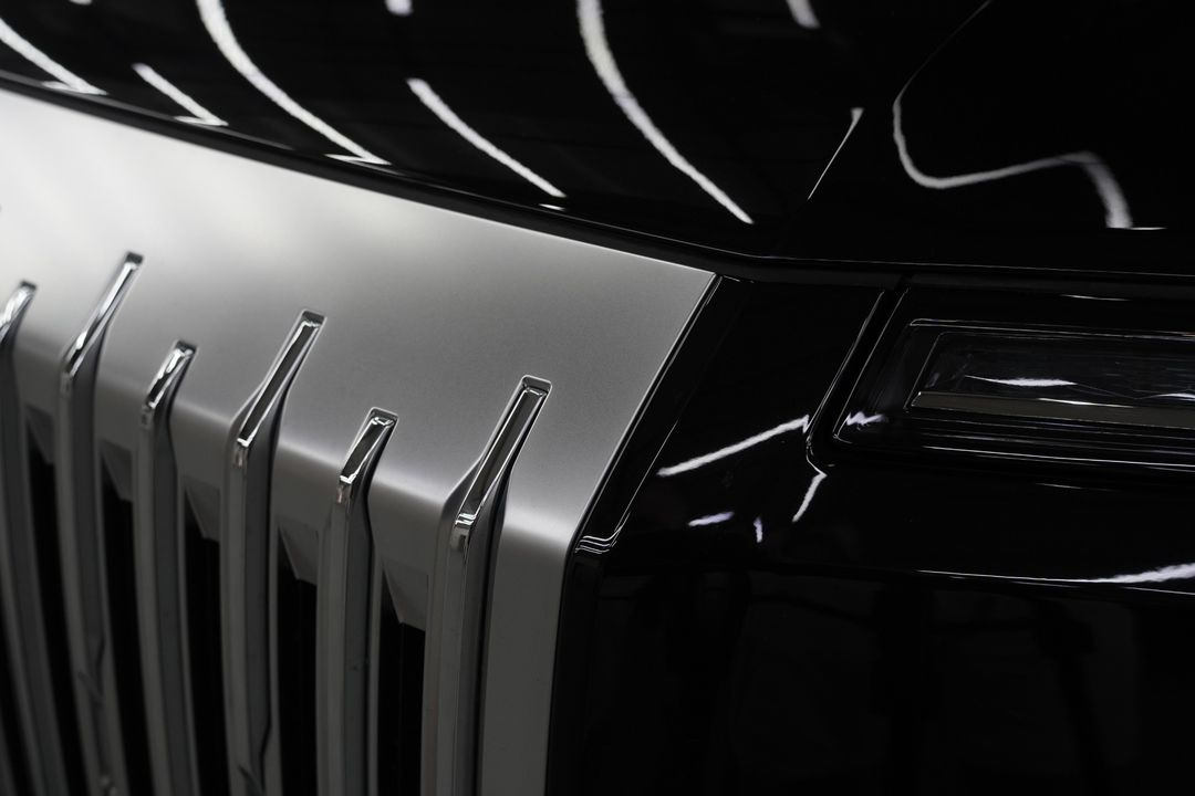 Close-up of the vertical silver grille bars and the front corner of the black ZEEKR 9X.