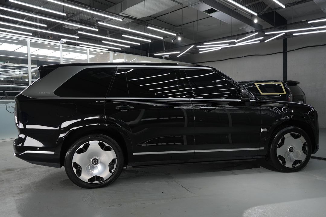 Side profile of the black ZEEKR 9X at IPD with bright trim along the sills and the rear pillar, and silver wheels.